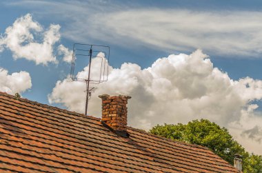 Evin çatısı üzerinde beyaz bulutlar