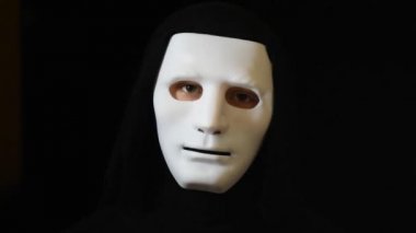 Beyaz maskeli karanlıktaki adam