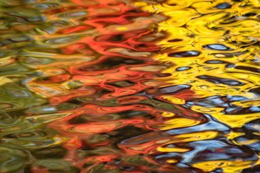 Gün batımında bir dağ nehrinde yansıma