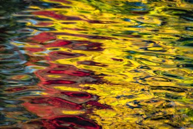 Gün batımında bir dağ nehrinde yansıma