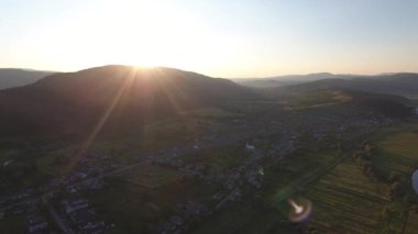 Gün batımında bir manastır olan dağ vadisindeki bir köyün hava görüntüsü.