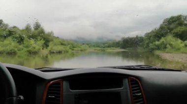 Yağmurda bir dağ nehrinde SUV