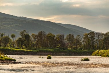 Gün batımında bir dağ nehrinin manzarası