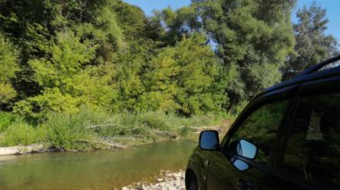 Yazın bir dağ nehrinde SUV