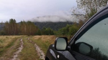 Yağmur sırasında bir dağ ormanında SUV.