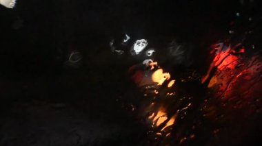 Yağmur sırasında şehir trafiğinde arabaların doğal farları.