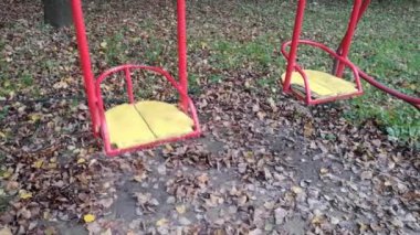 Düşen yapraklarla boş bir salıncak