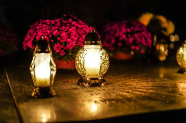 Mezarda dikilen mezar mumları. Azizler Günü 'nde mezarlıkta fenerler..