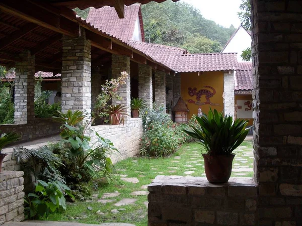 Interior gardens of the Leymebamba mummy museum, rustic Andean-style construction, stone walls and pillars and wooden roof