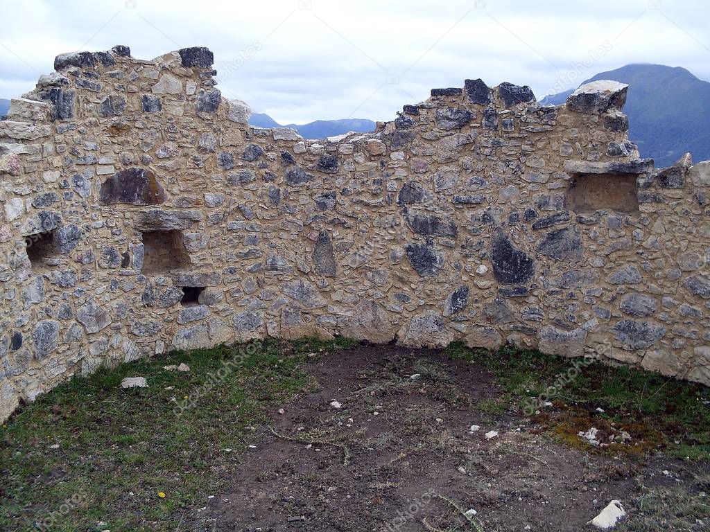 Interior wall of a circular house on the second level of the Kuelap fortress, seen the Andean mountains in the background