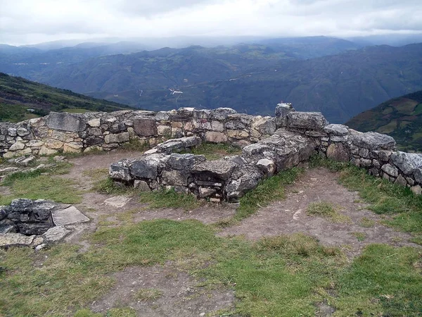 雲の日の底にアンデス山脈を見下ろすサイロと家族の墓を示すKuelap要塞の3階にある円形の家の内部 — ストック写真
