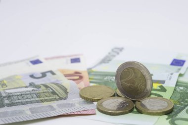 Gruplanmış Euro banknotlar ve madeni paralar. Beyaz arka planda para ve finans kavramı