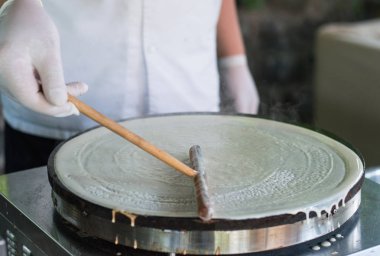 Bir restoran mutfağında bir aşçı tarafından krep pişirme