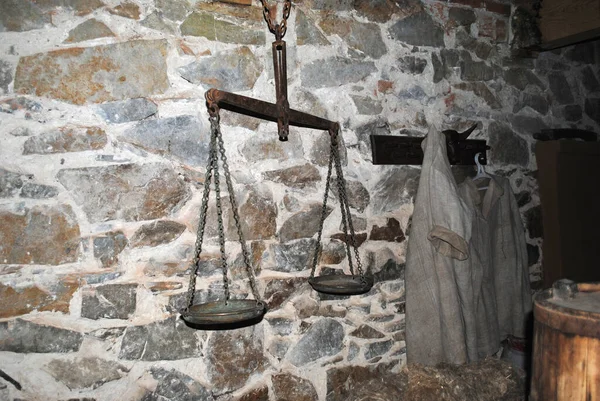 antique scales on a stone wall, workwear