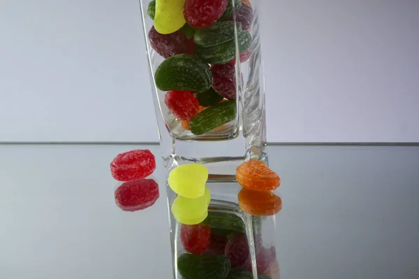 Bunte Leckere Bonbons Einem Glasbecher Auf Dem Spiegel Die Reflexion — Stockfoto