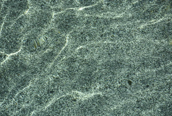 水中の天然花崗岩 波はユニークなパターンを作成します — ストック写真