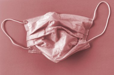 Gül arka planında koruyucu maske. Tek kullanımlık yüz maskesi ağız ve burnu kapatır. Sağlık sigortası Coronavirus karantinası, hijyen konsepti. Koronavirüsü önle