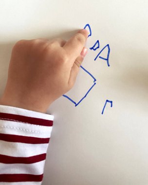 Küçük çocuğun eli çizimleri gösteriyor. Üst görünüm