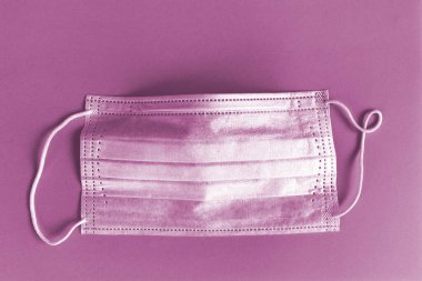 Leylak arka planında koruyucu maske. Tek kullanımlık yüz maskesi ağız ve burnu kapatır. Sağlık sigortası Coronavirus karantinası, hijyen konsepti. Koronavirüsü önle