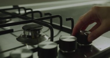 Yakın plan çekim. Kadın eli ocağın üstünde ocağı yakar. 4k