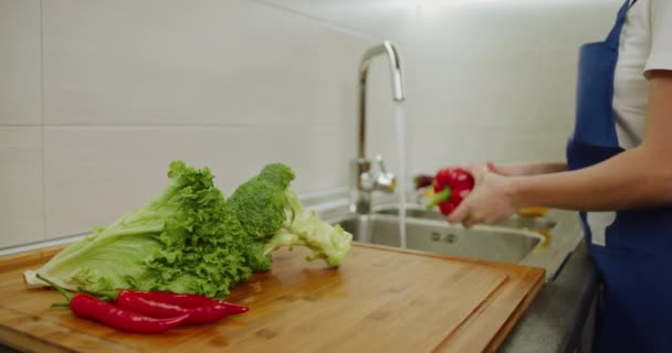 Prise de vue rapprochée. Les femmes lavent les légumes dans l'évier. Tirer depuis le côté. 4k — Video