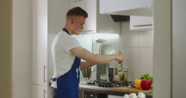 Adam tavada kaynamış yemekleri pişiriyor ve onları tuzluyor. 4k