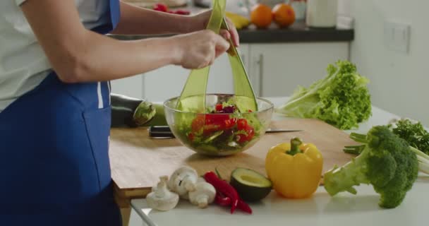 La mujer está mezclando todos los ingredientes de la ensalada. Preparación de ensaladas. 4K — Vídeo de stock
