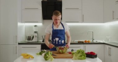 Bir adam kulaklıkla müzik dinliyor ve dans ediyor. Salata denemek istiyor. Salata hazırlığı. 4K