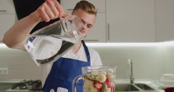 Man is pouring water into the blender bowl and closing it. Making smoothies. 4K — Stock Video