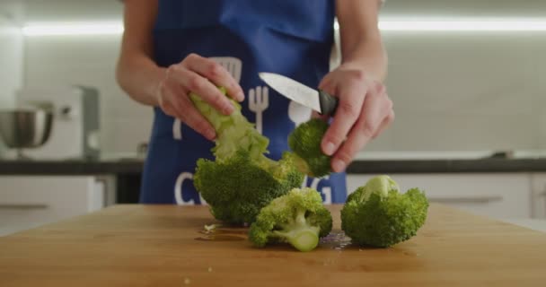 Prise de vue rapprochée. Une femme coupe le brocoli en particules. 4K — Video