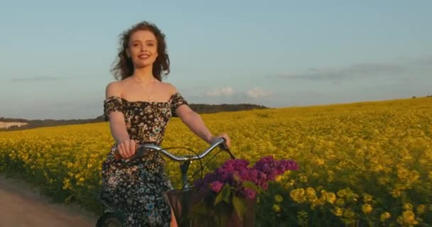 Dziewczyna w pięknej sukience jeździ na rowerze i uśmiecha się. Klasyczny rower. 4K — Wideo stockowe