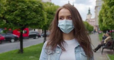 Yakın plan çekim. Gülümseyen kız koruyucu maskesini çıkarıyor ve mutlu. 4K