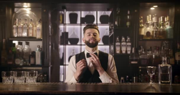 O barman está sorrindo e ajustando o laço. 4k — Vídeo de Stock
