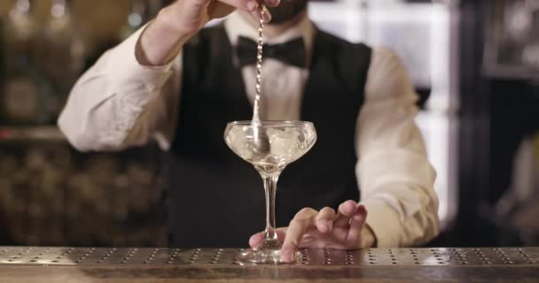 Een close-up opname. De barman draait het ijs in glas met de barlepel. 4k — Stockvideo