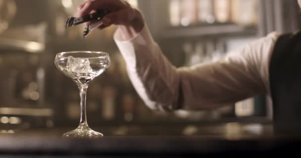 Nahaufnahme. Der Barkeeper füllt ein Glas mit Eis. 4k — Stockvideo