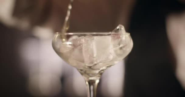 Nahaufnahme. Barkeeper dreht das Eis mit dem Stablöffel in Glas. 4k — Stockvideo