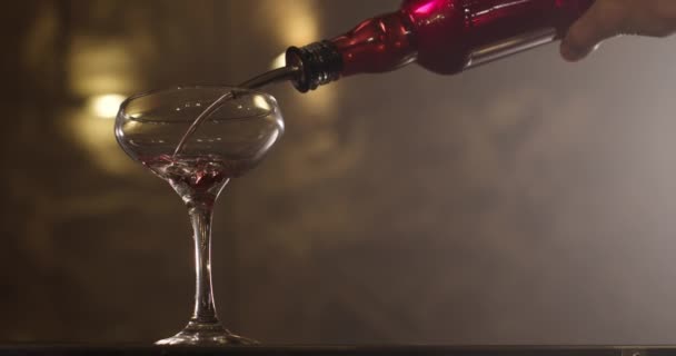 Een close-up opname. De barman schenkt een drankje uit een fles in een glas. 4k — Stockvideo