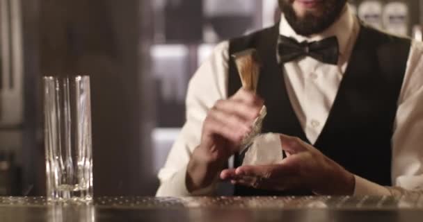 Disparos de cerca. El camarero está aplastando un cubo de hielo para tomar un cóctel. 4K — Vídeo de stock