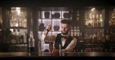 Barmen bir kokteyle buz karıştırıyor ve onu bir dilim limonla süslüyor. 4K