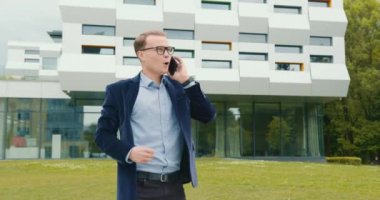 İş adamı telefonda konuşuyor ve çok mutlu. Elini 