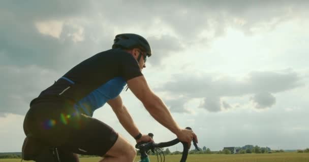 Ein Radfahrer ist auf der Autobahn unterwegs. Er fährt langsam. Training auf dem Fahrrad. Im Hintergrund scheint die Sonne. 4K — Stockvideo