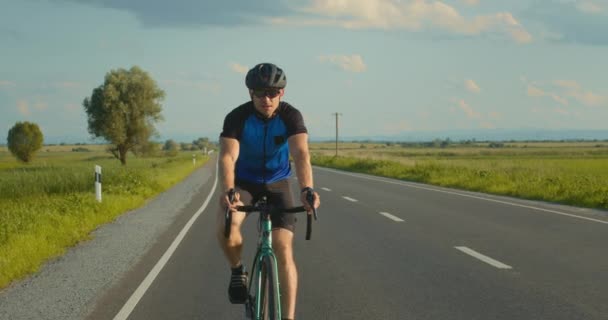 En cyklist åker längs motorvägen i långsam takt. Träning på cykeln. 4K — Stockvideo