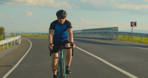 Rowerzysta jedzie autostradą w powolnym tempie. Trening na rowerze. Włącza hamulce i się zatrzymuje. 4K — Wideo stockowe