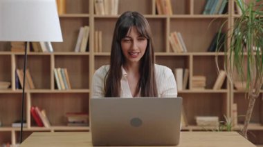 Olumlu gülümseyen beyaz kadın heyecanla yumruk atıyor ve gülüyor. Uzun bir çabadan sonra başarıyı kutlamak veya önemli bir görevi tamamlamak ve bu süreçte motive olmak.