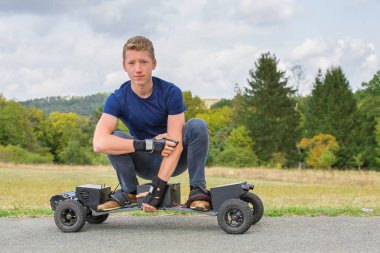 Doğada yolda elektrik mountainboard beyaz delikanlı sürücüler