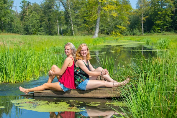 两个年轻的白种妇女坐在溪流自然 — 图库照片