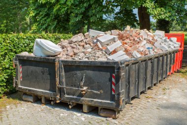 Büyük metal atık konteyner taş, tuvalet ve diğer moloz dolu