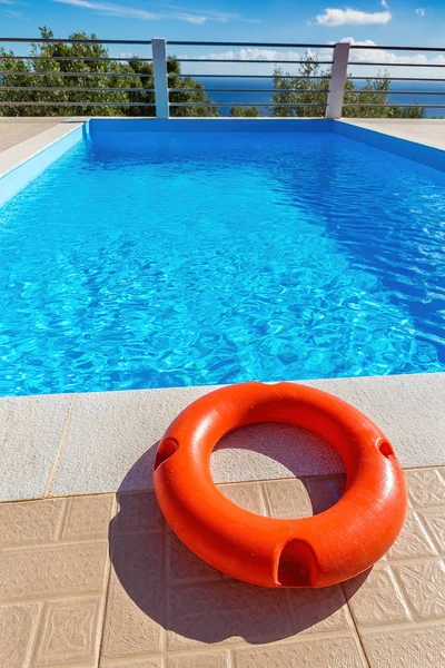 Boa di salvataggio arancione che giace in piscina — Foto Stock