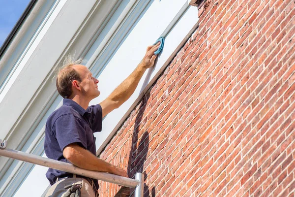 Kaukasische schilder reinigt dakgieten met doek — Stockfoto