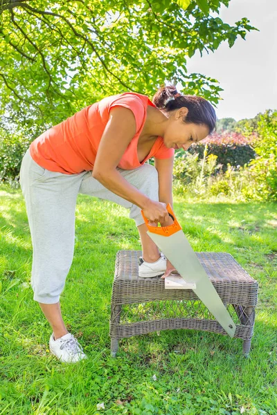 Kolumbianerin sägt im Freien mit Handsäge Holz — Stockfoto